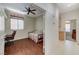 A cozy bedroom is displayed with a desk, chair, floral sofa, hardwood floors, and a ceiling fan at 9220 Evergreen Canyon Dr, Las Vegas, NV 89134