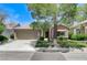 Charming single-story home featuring desert landscaping, mature trees, and a spacious two-car garage at 9220 Evergreen Canyon Dr, Las Vegas, NV 89134