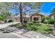 Inviting single-story home showcasing a well-manicured lawn, desert landscaping, and a tile roof at 9220 Evergreen Canyon Dr, Las Vegas, NV 89134