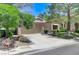 Welcoming home with desert landscaping, mature trees, and a two-car garage at 9220 Evergreen Canyon Dr, Las Vegas, NV 89134