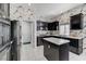 Modern kitchen with stainless steel appliances, an island, marble countertops, and patterned wallpaper at 9220 Evergreen Canyon Dr, Las Vegas, NV 89134