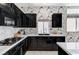 Functional kitchen with stainless steel appliances, marble countertops, and black cabinets at 9220 Evergreen Canyon Dr, Las Vegas, NV 89134