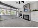 Cozy living room with a fireplace, built-in cabinets, and natural light from the surrounding windows at 9220 Evergreen Canyon Dr, Las Vegas, NV 89134