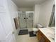 A clean bathroom featuring a glass-enclosed shower, white fixtures, and tile floors at 9580 W Reno Ave # 283, Las Vegas, NV 89148