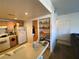 Functional kitchen space with wood cabinets, white appliances and breakfast bar with pantry shelves at 9580 W Reno Ave # 283, Las Vegas, NV 89148