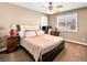 Comfortable bedroom featuring a ceiling fan, plush bedding, and a well-lit desk area by the window at 10612 Gum Tree Ct, Las Vegas, NV 89144