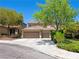 Charming home featuring a three-car garage, lush trees, and a tile roof at 10612 Gum Tree Ct, Las Vegas, NV 89144