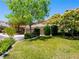 Well-maintained front yard with lush green grass, mature trees, and desert landscaping at 10612 Gum Tree Ct, Las Vegas, NV 89144