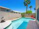 A backyard swimming pool is enclosed by a wall, grass and lush tropical foliage at 10612 Gum Tree Ct, Las Vegas, NV 89144