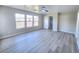 Bright bedroom with large windows, new flooring, and a ceiling fan, with an open door to the hallway at 11185 Saddle Iron St, Las Vegas, NV 89179