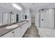 Well-lit bathroom featuring double sinks, granite counters, and a walk-in glass shower at 12816 Alcores St, Las Vegas, NV 89141