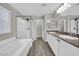 Bathroom with gray cabinets, double sink and large bathtub with glass shower at 12816 Alcores St, Las Vegas, NV 89141