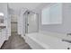 Bathroom featuring a walk-in glass shower and a luxurious soaking tub by a window at 12816 Alcores St, Las Vegas, NV 89141