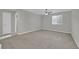Bright bedroom with neutral walls, plush carpet, ceiling fan and a large window at 12816 Alcores St, Las Vegas, NV 89141