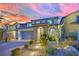 Charming home featuring a brick driveway, tidy front landscaping and beautiful evening skies at 12816 Alcores St, Las Vegas, NV 89141