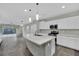 Bright, open kitchen featuring modern white cabinets, large island, and stainless steel appliances at 12816 Alcores St, Las Vegas, NV 89141