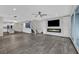 Open-concept living space featuring a linear fireplace, tv, and modern staircase at 12816 Alcores St, Las Vegas, NV 89141