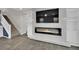 Living room with a modern fireplace, built-in shelving, and a staircase leading upstairs at 12816 Alcores St, Las Vegas, NV 89141