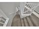 Carpeted staircase with white railing that leads down to the living area at 12816 Alcores St, Las Vegas, NV 89141