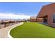 Backyard with artificial turf, desert landscaping, wrought iron fencing, and mountain views at 1398 Pin Cushion Rdg, Mesquite, NV 89034