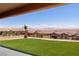 Artificial turf backyard with desert landscaping surrounded by wrought iron fence and mountain views at 1398 Pin Cushion Rdg, Mesquite, NV 89034