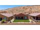 A low fence contains a backyard with a lawn and desert landscaping, providing a private and serene outdoor space at 1398 Pin Cushion Rdg, Mesquite, NV 89034