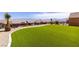 Expansive backyard features lush artificial turf, desert landscaping, and stunning mountain views at 1398 Pin Cushion Rdg, Mesquite, NV 89034