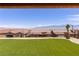 Stunning backyard features lush artificial turf, desert landscaping, and mountain views from the covered patio at 1398 Pin Cushion Rdg, Mesquite, NV 89034
