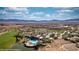 Panoramic aerial shot of the community showcasing the pool, golf course, and stunning mountain backdrop at 1398 Pin Cushion Rdg, Mesquite, NV 89034