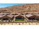 Charming single-story home featuring a low fence, a backyard lawn and desert landscaping against a mountain backdrop at 1398 Pin Cushion Rdg, Mesquite, NV 89034