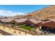Charming single-story home featuring a low fence, a backyard lawn and desert landscaping against a mountain backdrop at 1398 Pin Cushion Rdg, Mesquite, NV 89034