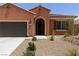 Single-story house boasts an attached garage, arched entrance, and low-maintenance desert landscaping at 1398 Pin Cushion Rdg, Mesquite, NV 89034