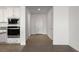 Hallway with neutral tile flooring and white walls, leading to the kitchen with stainless steel appliances at 1398 Pin Cushion Rdg, Mesquite, NV 89034