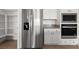 Bright kitchen features stainless steel refrigerator, microwave, oven, and white cabinets at 1398 Pin Cushion Rdg, Mesquite, NV 89034