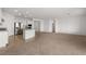 Spacious living area with neutral carpeting and tile flooring, complemented by a modern kitchen at 1398 Pin Cushion Rdg, Mesquite, NV 89034