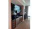Dark wood kitchenette with a stainless steel sink, microwave, refrigerator, and overhead lighting at 145 E Harmon Ave # 2409, Las Vegas, NV 89109