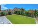 This backyard features artificial grass, a hardscaped patio area, and lush landscaping at 1574 Ward Frontier Ln, Henderson, NV 89002