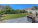 Backyard with artificial grass, patio, fire pit, and green landscaping at 1574 Ward Frontier Ln, Henderson, NV 89002