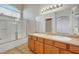 Bathroom featuring double sinks, wood cabinets, and a shower at 1574 Ward Frontier Ln, Henderson, NV 89002