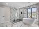 Modern bathroom showcasing a walk-in shower, soaking tub, and marble tiling with gold accents at 1600 Becke Cir, Las Vegas, NV 89104