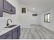 Bright room with a small kitchenette, modern cabinets, and wood-style flooring at 1600 Becke Cir, Las Vegas, NV 89104