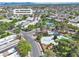 Wide aerial view of community featuring a swimming pool, tennis courts, lush trees, and tree lined streets at 163 Greenbriar Townhouse Way, Las Vegas, NV 89121