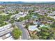 Wide aerial view of community featuring a swimming pool, tennis courts, lush trees, and tree lined streets at 163 Greenbriar Townhouse Way, Las Vegas, NV 89121