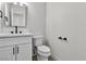 Modern bathroom featuring white cabinets, a sleek mirror, and a stylish toilet at 163 Greenbriar Townhouse Way, Las Vegas, NV 89121