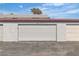 White detached garages with doors, concrete driveway and stucco walls at 163 Greenbriar Townhouse Way, Las Vegas, NV 89121