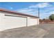 View of the exterior of the detached garages with white doors at 163 Greenbriar Townhouse Way, Las Vegas, NV 89121