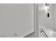 Hallway with white walls, neutral carpet, and white trim leading to a door and with modern light fixture at 163 Greenbriar Townhouse Way, Las Vegas, NV 89121