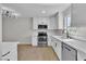 Bright kitchen featuring white cabinets, stainless steel appliances, and quartz countertops at 163 Greenbriar Townhouse Way, Las Vegas, NV 89121