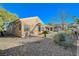 Landscaped backyard with desert plants, statues, a covered patio, and a view of the house at 2039 Colvin Run Dr, Henderson, NV 89052