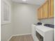 Well-equipped laundry room features a washer, dryer, and overhead storage cabinets at 2039 Colvin Run Dr, Henderson, NV 89052